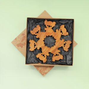 A round wooden koala design trivet in a recycled card presentation box