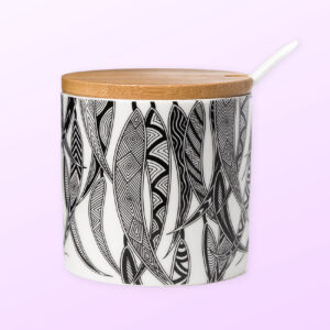 Ceramic sugar bowl with a ceramic spoon and a bamboo lid. The sugar bowl has artwork by Mick Harding on it. It is black and white.