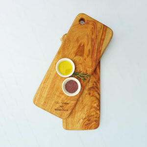 Two small wooden chopping boards with a dish of olive oil and a dish of salt